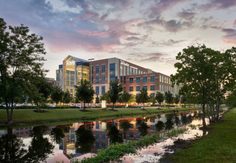 A photo of a hospital next to a creek.