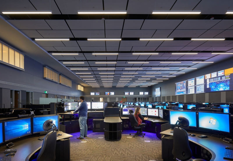 People sitting in a room filled with computers at an operations center.